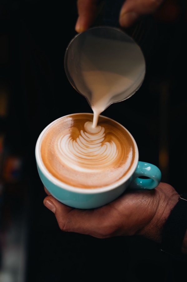 A barista pouring latte art